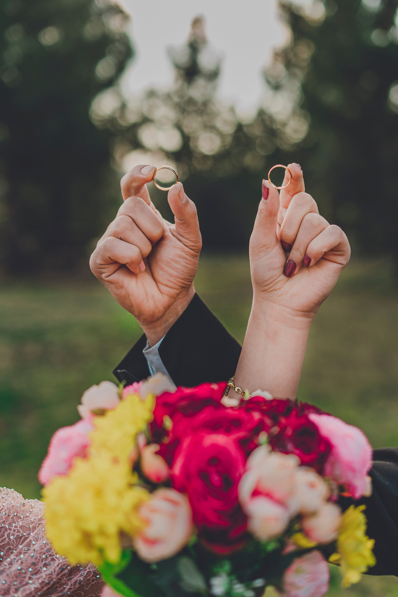 Photograph of Hands Holding Wedding Rings